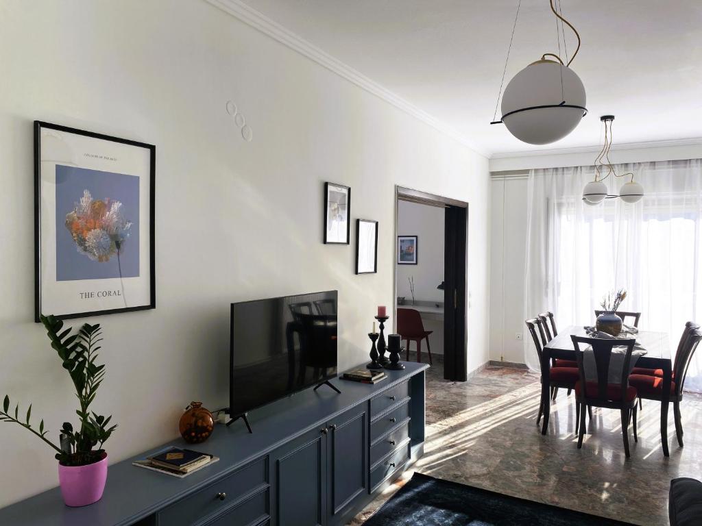 een woonkamer met een televisie en een eetkamer bij Serene Apartment with Breathtaking Sea View in Thessaloniki