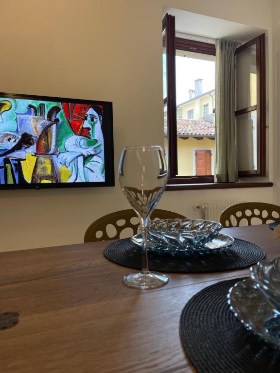- une table à manger avec un verre de vin dans l'établissement Bicamere deluxe nel cuore di Udine by DOCG apartment, à Udine