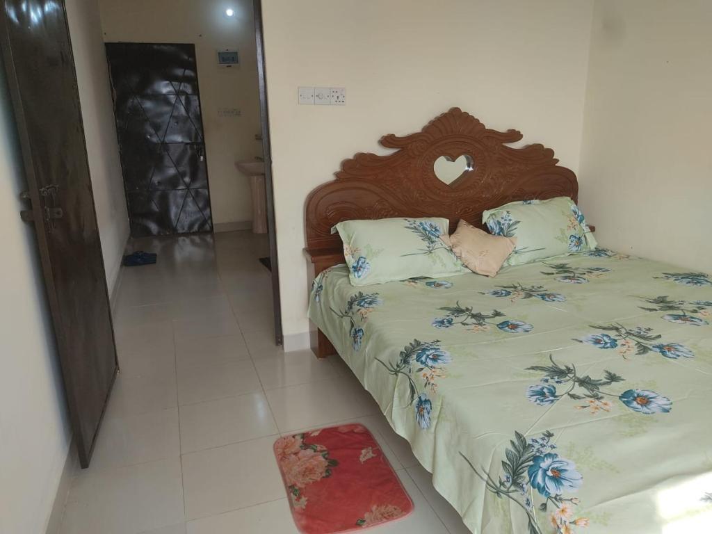 a bedroom with a bed with a wooden headboard at Secured Family Studio Apartment-near Airport,AC,Fridge,WiFi,Stove in Dhaka