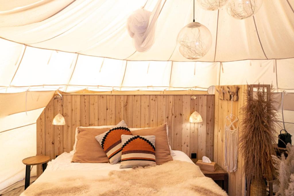 1 dormitorio con 1 cama en una tienda de campaña en Comfort Tipi Marie, Tipi Bo Deluxe & tent Nicolaï - 'Glamping in stijl', en Lembeke