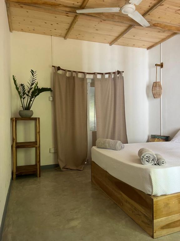 um quarto com uma cama e uma ventoinha de tecto em KOMOREBI MADIHA em Madihe East