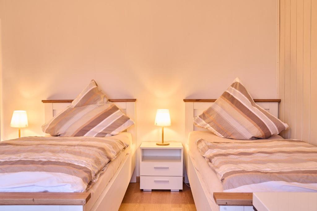 Duas camas sentadas uma ao lado da outra num quarto em Ferienwohnung Brockenblick em Rennau