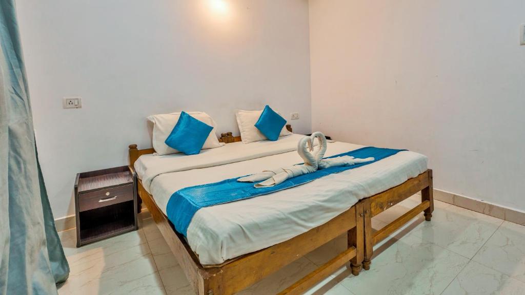 a bedroom with a bed with blue and white sheets at QnQ Beach Walk in Calangute