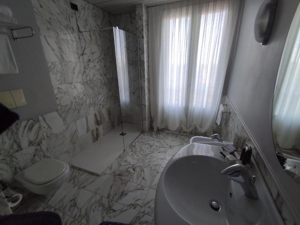 a white bathroom with a sink and a toilet at Vittoria Parc Hotel in Bari