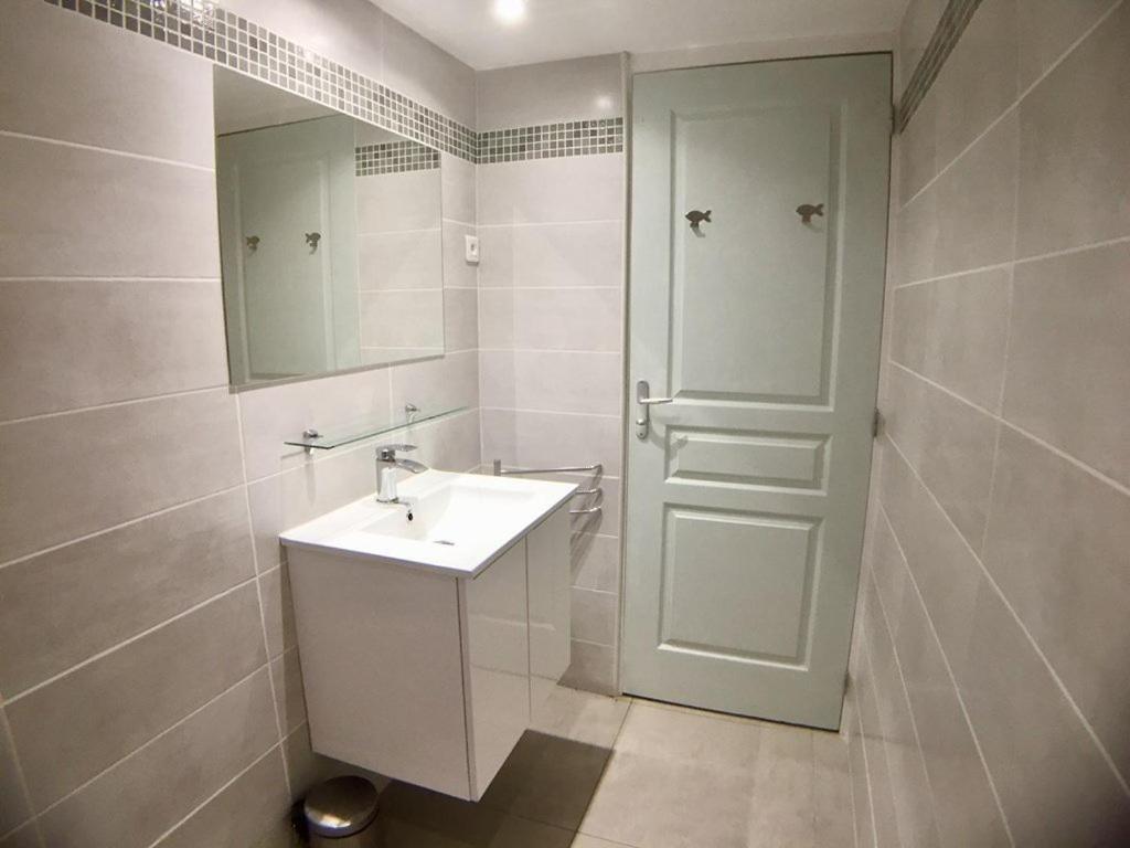 a white bathroom with a sink and a mirror at Villa Occhiatana, Santa Giulia in Porto-Vecchio