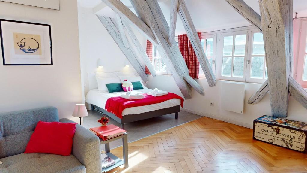 um quarto com uma cama e um sofá num quarto em Duplex Le coup de coeur - Hyper Centre em Colmar