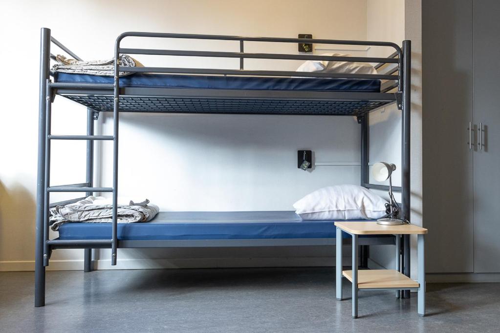 1 dormitorio con 2 literas y mesa en Hostel Van Gogh, en Bruselas