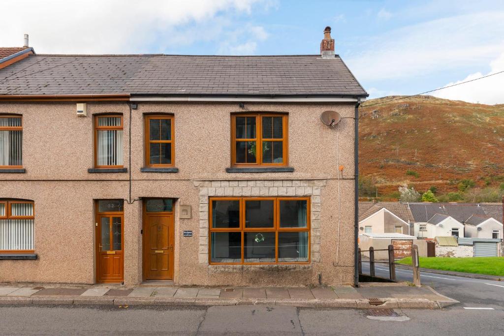 a brick building with orange doors on a street at The Space by Afan Valley Escapes in Port Talbot