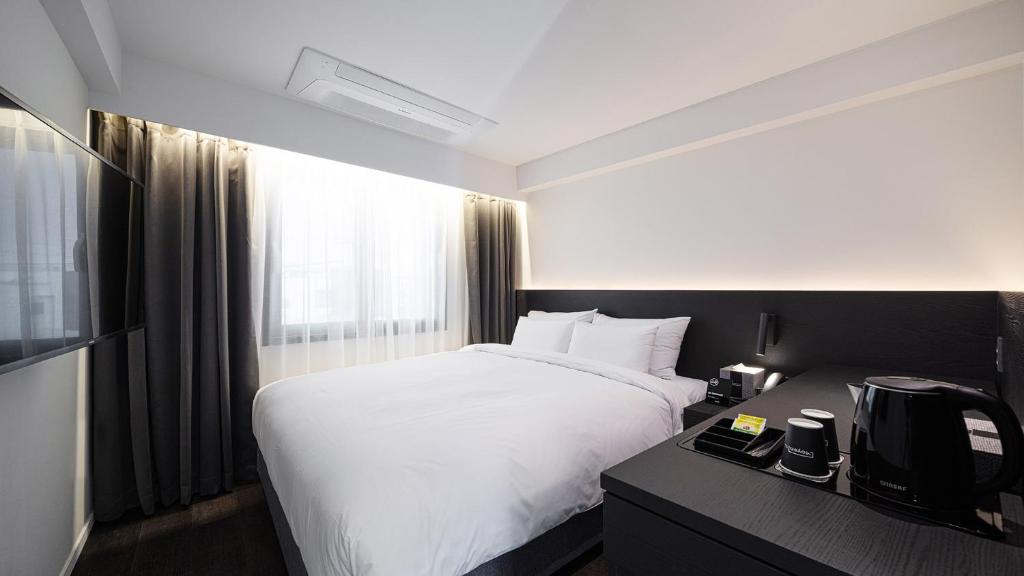Postel nebo postele na pokoji v ubytování Moyen Hotel
