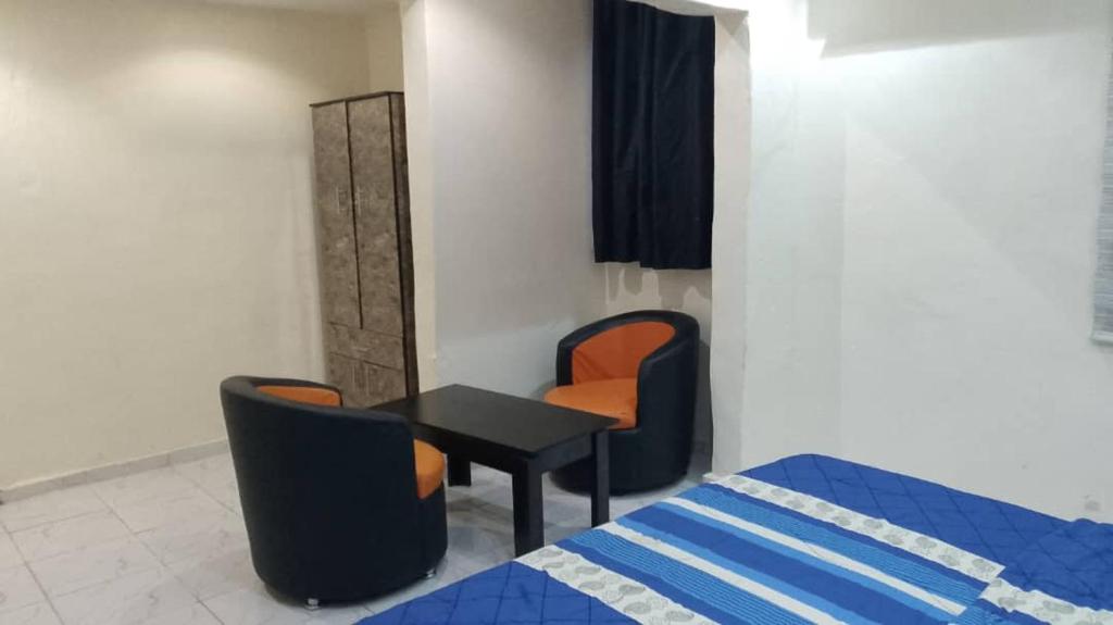JEFFOSA Hotel & Suites في لاغوس: غرفة بسرير وطاولة وكراسي