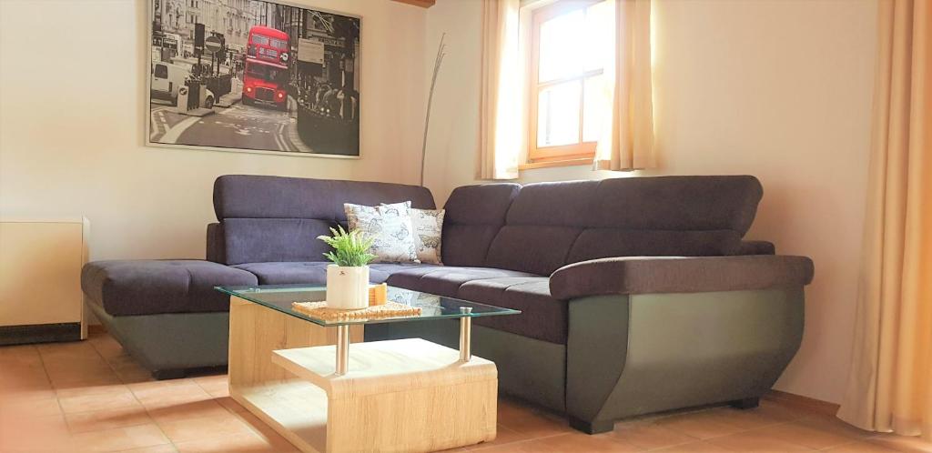 ein Wohnzimmer mit einem Sofa und einem Tisch in der Unterkunft Ferienhaus Pappenheimer in Regen