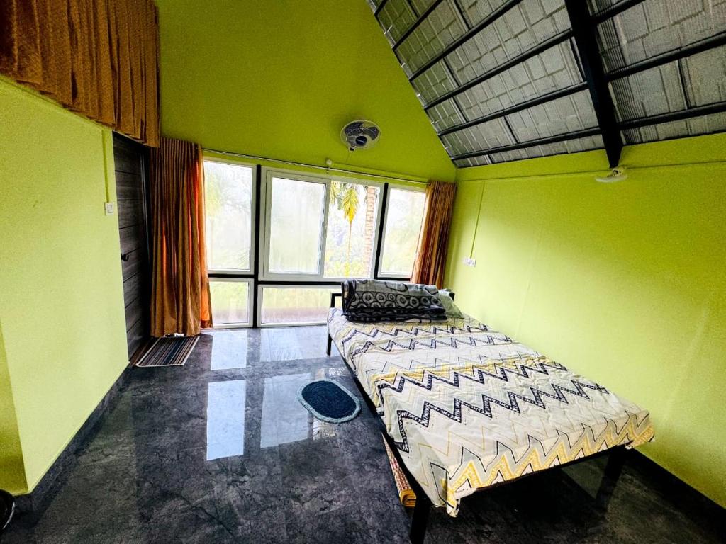 1 dormitorio con 1 cama en una habitación con paredes verdes en Nandhanam Homestay, en Palakkad