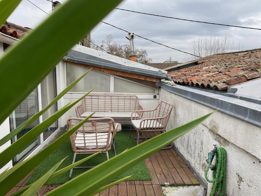 d'une terrasse avec 2 chaises et une table sur un balcon. dans l'établissement Logement familial Etage privatif, à Bordeaux