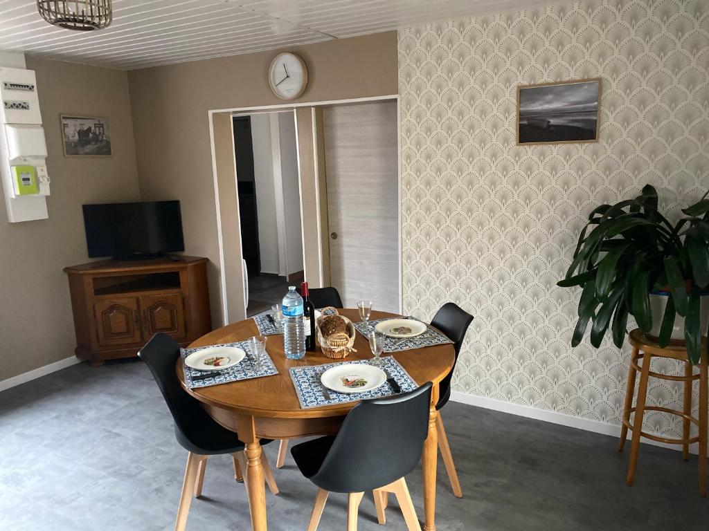 ein Esszimmer mit einem Holztisch und Stühlen in der Unterkunft chez mémère 3étoiles in Saint-Blimont