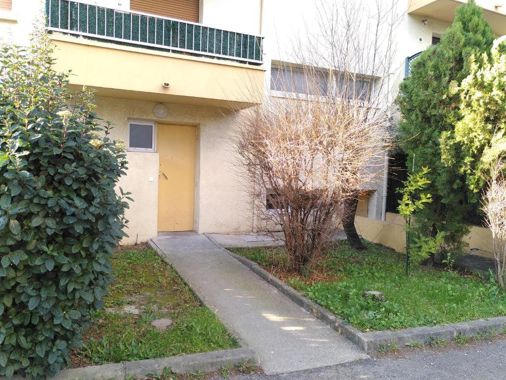 a house with a yellow door and some bushes at Appart T3 Spacieux + Terrasse in Montpellier