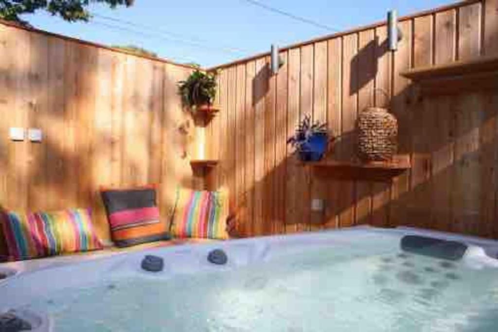 Saint-PompontGîte Le Maine Libre* SPA* Calme et authenticité的木制围栏前的热水浴池