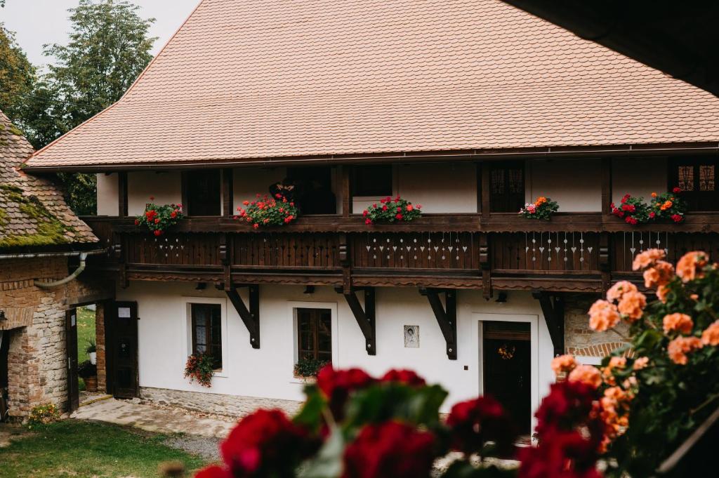 ein weißes Haus mit Blumen auf dem Balkon in der Unterkunft Statek Poštolka in Svitavy