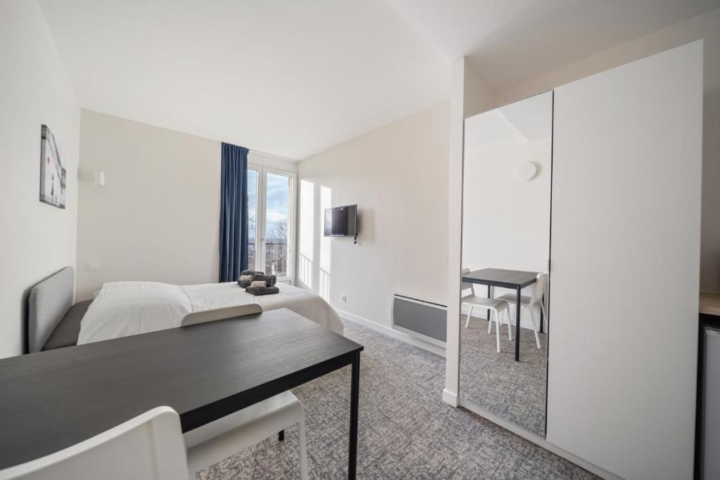 une chambre avec un lit, une table et un miroir dans l'établissement Le Mont neuf - Chambres avec cuisine au coeur de la nature type Appart'Hotel - sanitaires communs, à Perrigny