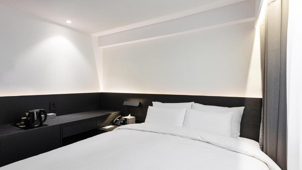 Postel nebo postele na pokoji v ubytování Moyen Hotel