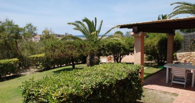 a patio with a table and chairs and trees at Villa Porto Giunco in Notteri