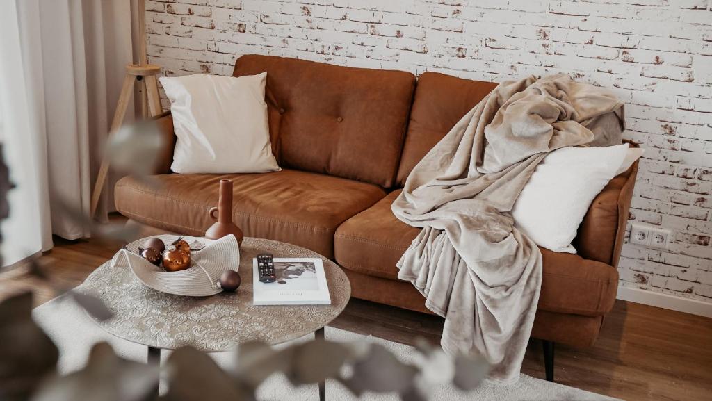 a living room with a brown couch with a blanket at Urban Suite - Detmold in Detmold