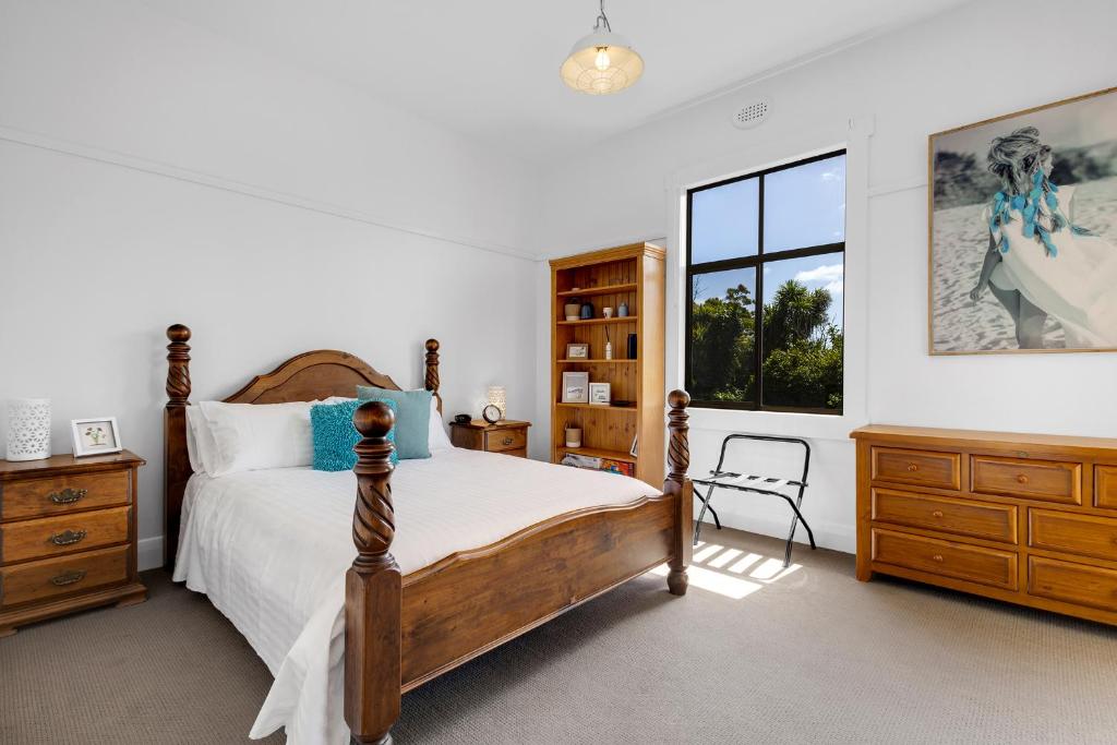 a bedroom with a bed and a window at Sea Glass Cottages Burnie Tasmania in Burnie
