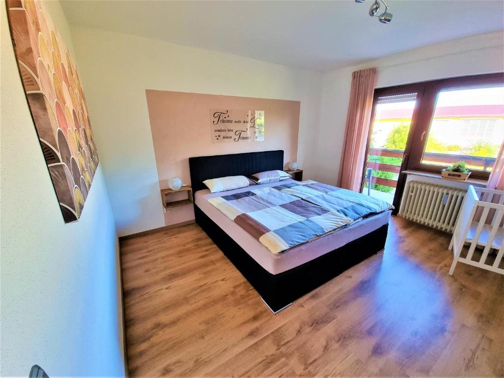 1 dormitorio con cama y ventana grande en Ferienwohnungen Pappenheimer, en Oberlangfurth