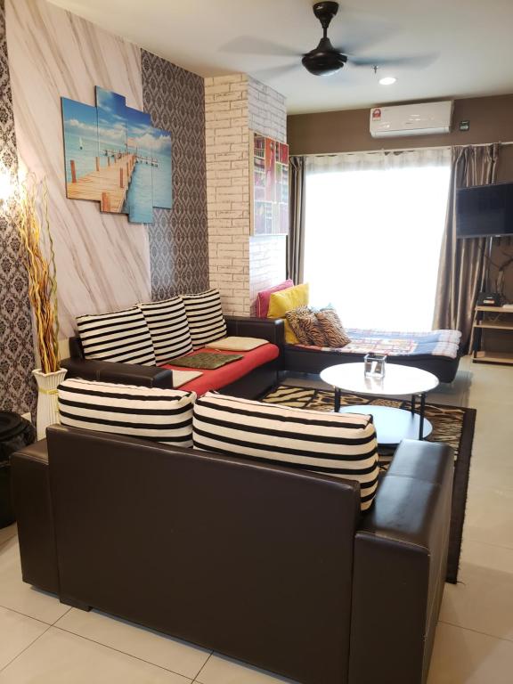 a living room with two couches and a table at The Mons inside Tower Regency Hotel and Apartments in Ipoh