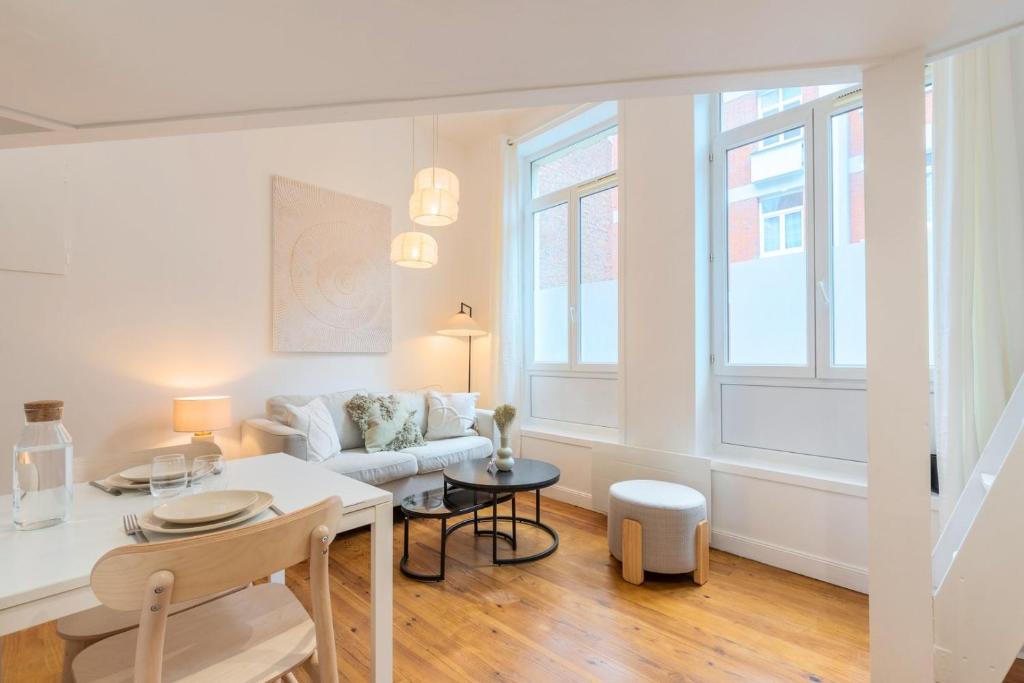 een woonkamer met een bank en een tafel bij Charming renovated and bright studio in the center in Lille