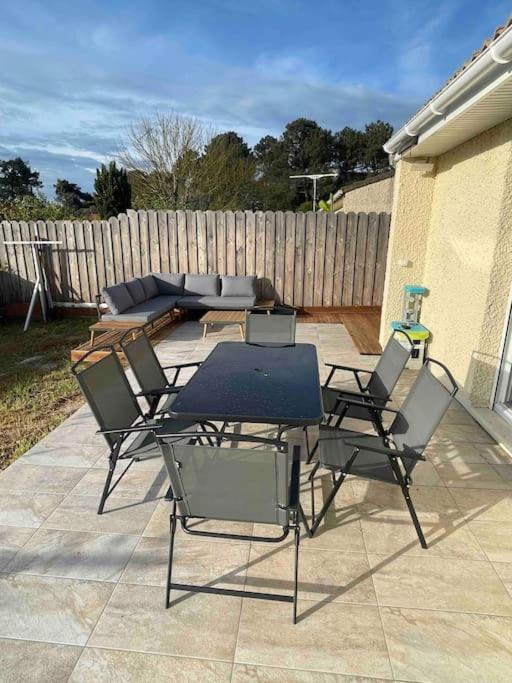 d'une terrasse avec des chaises, une table et un canapé. dans l'établissement Maison 6 personnes Soulac Climatisée Fibre, à Soulac-sur-Mer