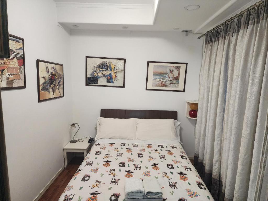 um quarto com uma cama e quadros na parede em V-Appartment em Tirana