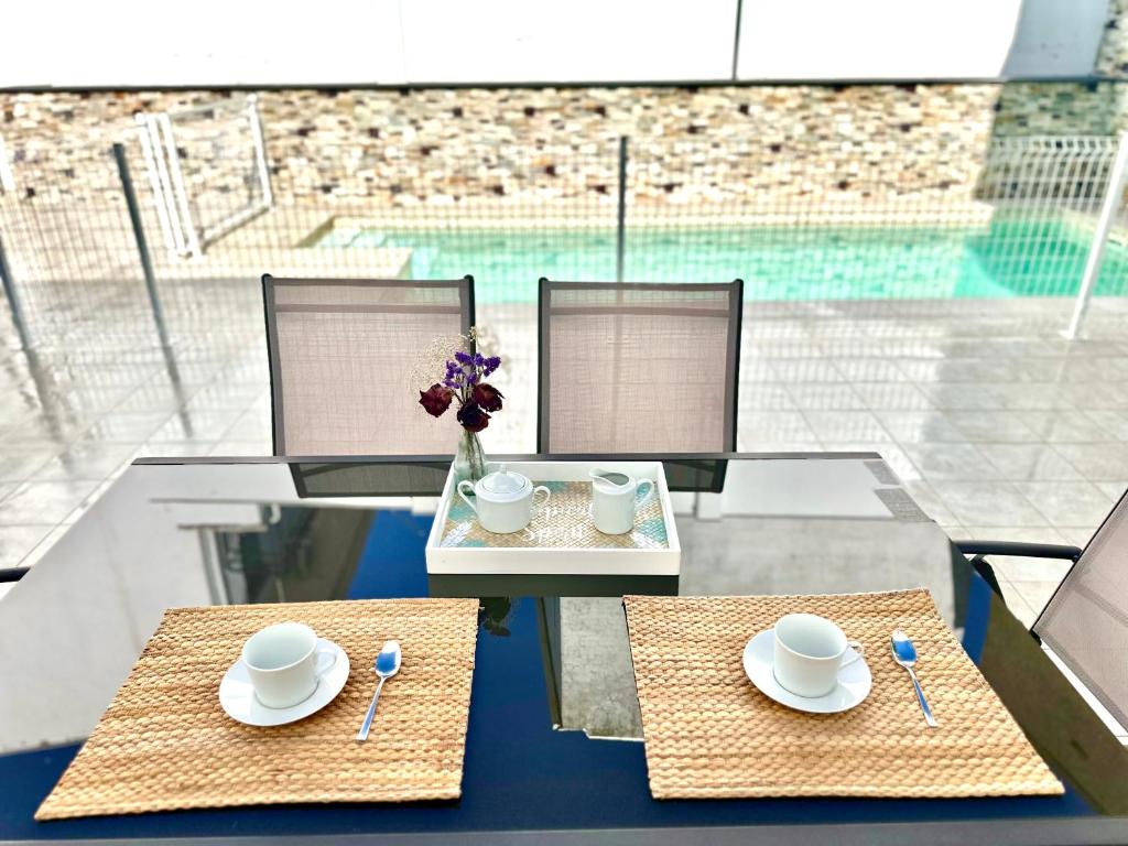 a table with two chairs and plates and a vase with flowers at CASA RURAL AREV in Herrera del Duque