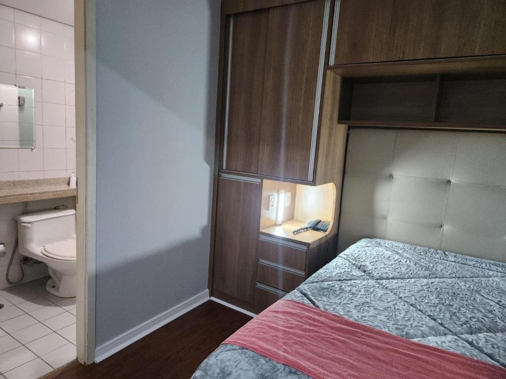 a bedroom with a bed and a bathroom with a toilet at Hotel Av Ibirapuera 2534 Moema São Paulo 3 in São Paulo