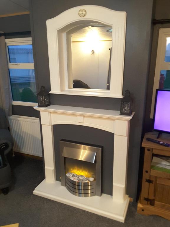 a fireplace with a mirror on top of it at Golden sands ingoldmells in Skegness