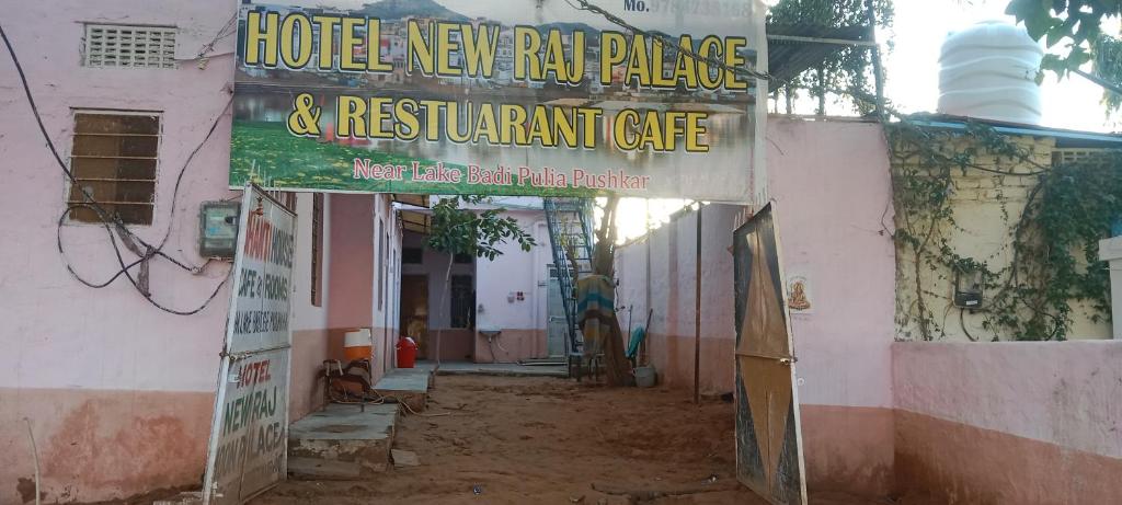 a building with a sign for a hotel new raw palace and restaurant cafe at Shanti palce hostel in Pushkar