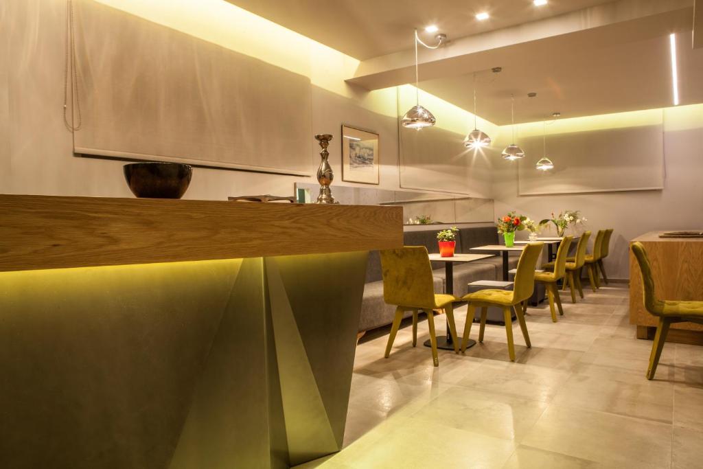 um restaurante com um bar com cadeiras e uma mesa em Anemos Rooms & Apartments em Nafplio