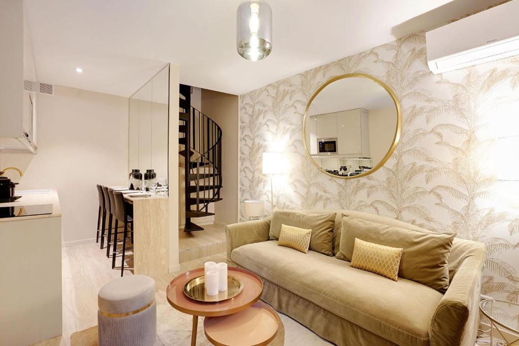 uma sala de estar com um sofá e um espelho em Rénovation Chic Appart 17th Terrace & Mezzanine em Paris