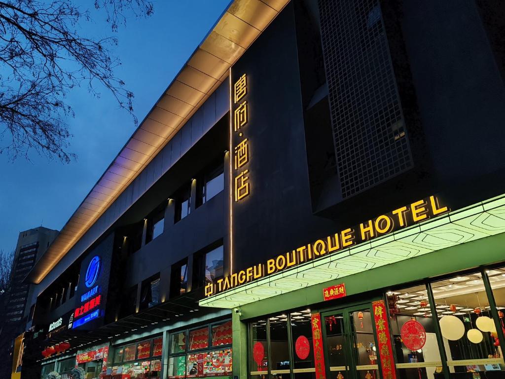 an urban boutique hotel with a sign on the building at Tang Palace Hotel - Beijing Sanlitun Gongti Store in Beijing
