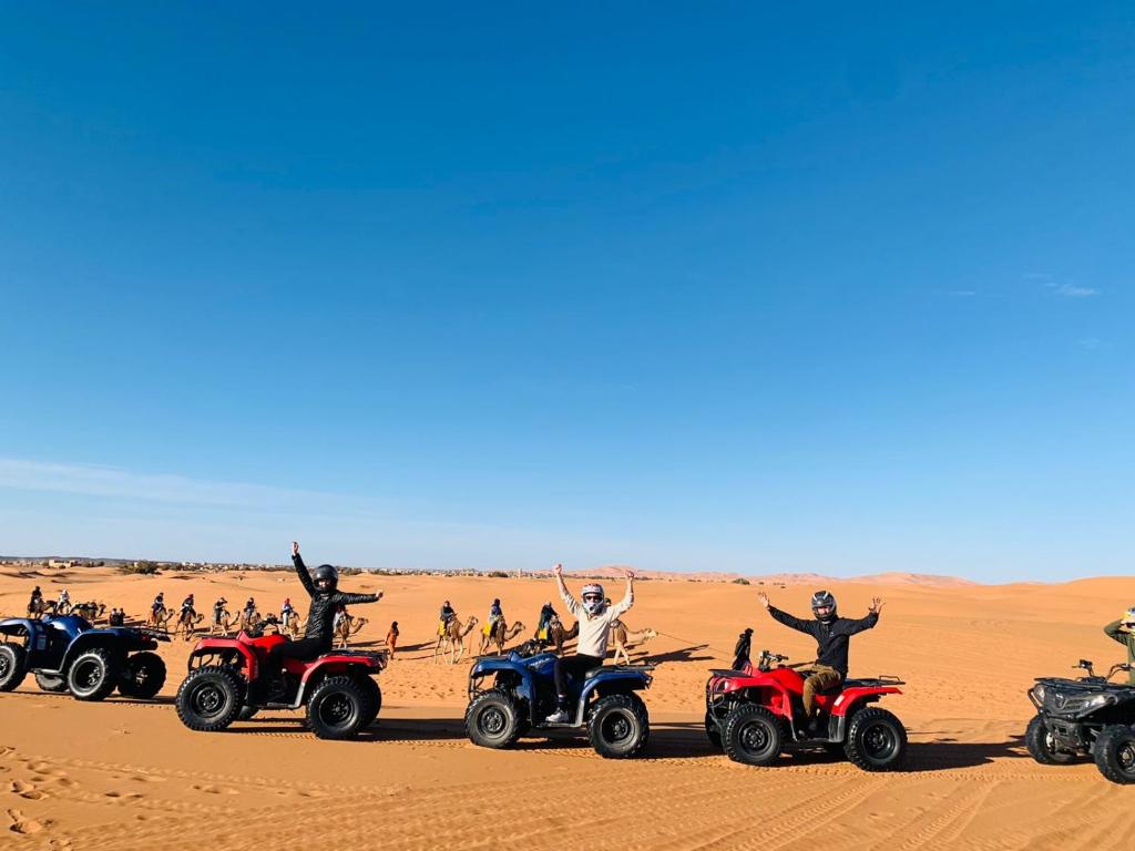 a group of people on atvs in the desert at Your Family Camp in Merzouga