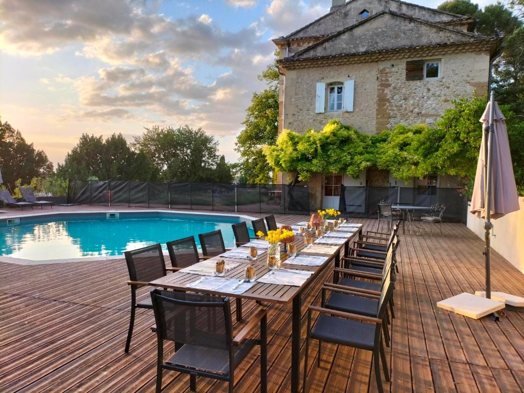 Château MontPlaisir charming b&b in Provence في فالريس: طاولة وكراسي خشبية بجانب مسبح