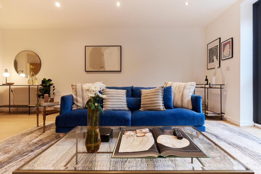 a living room with a blue couch and a table at The Putney Escape - Trendy 2BDR Flat with Terrace + Parking in London