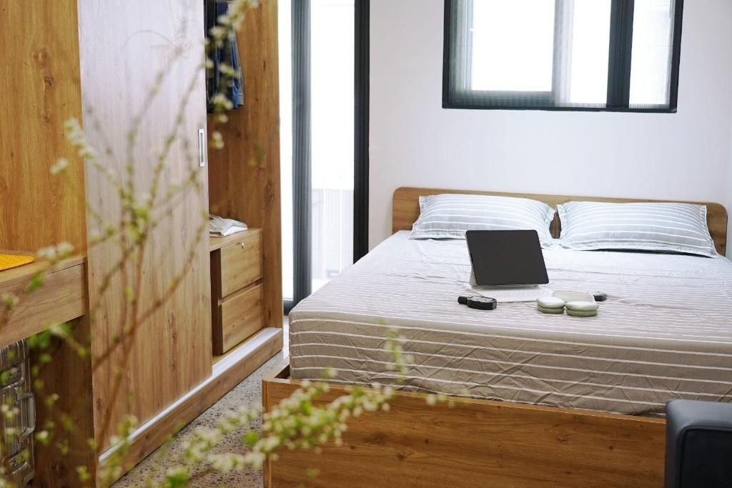 1 dormitorio con 1 cama con ordenador portátil en AN Studio NBK, en Ho Chi Minh