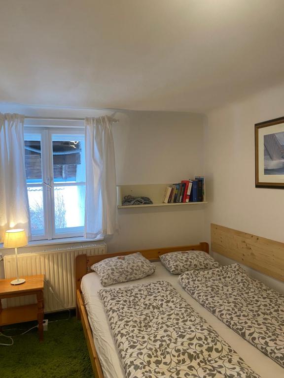 2 Betten in einem Schlafzimmer mit Fenster in der Unterkunft Weingut Martinshof in Sankt Ulrich