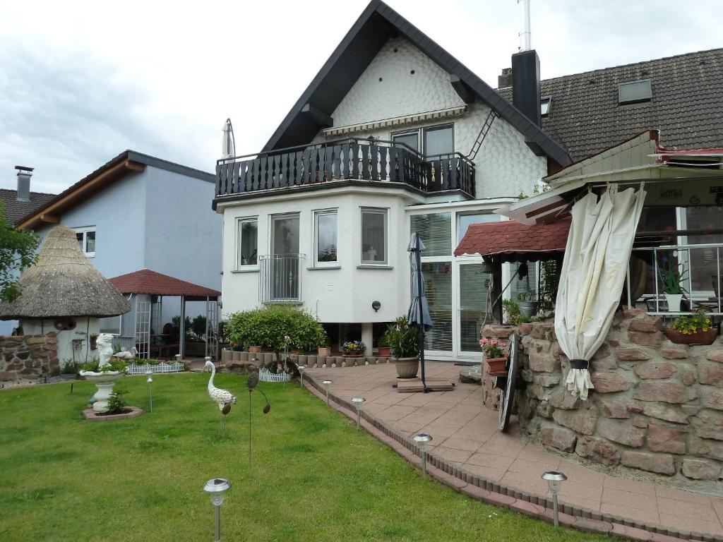 a white house with a balcony and a yard at Family Apartments Abuja in Rust