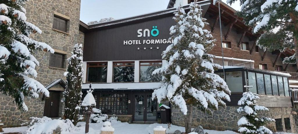 a hotel building with snow covered trees in front of it at Snö Hotel Formigal in Formigal