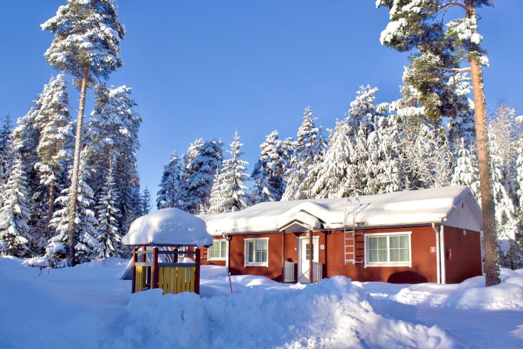 una cabaña en la nieve con árboles nevados en Ekokatti Cottages, en Vuokatti