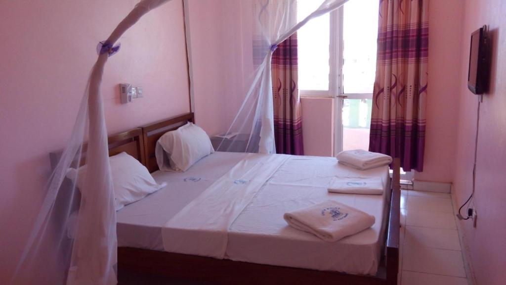 una camera da letto con un letto e due asciugamani di Checkpoint Inn Hotel, Mombasa a Mombasa