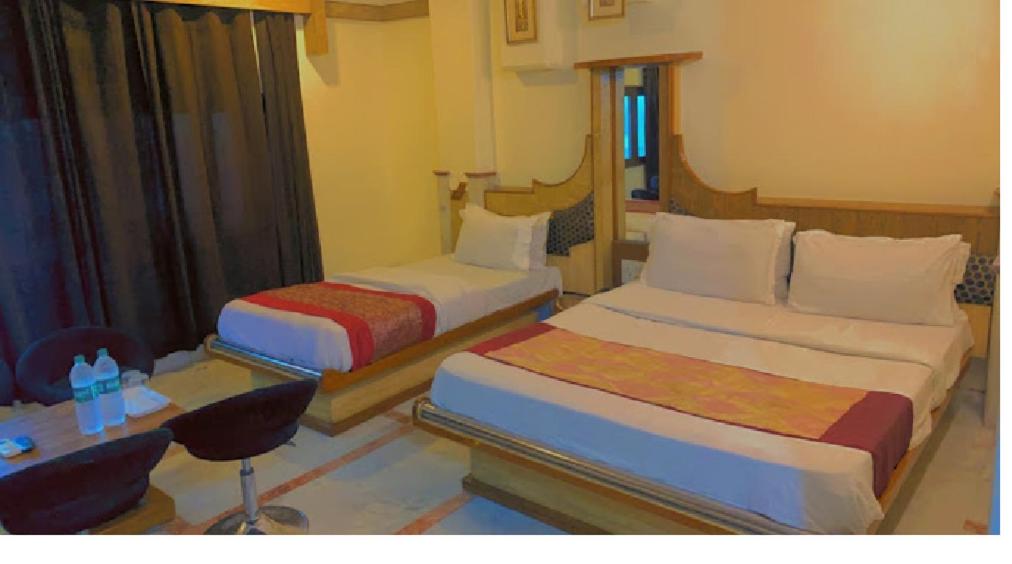 Habitación de hotel con 2 camas y escritorio en Hotel Cottage Crown Plaza By My Rooms en Nueva Delhi