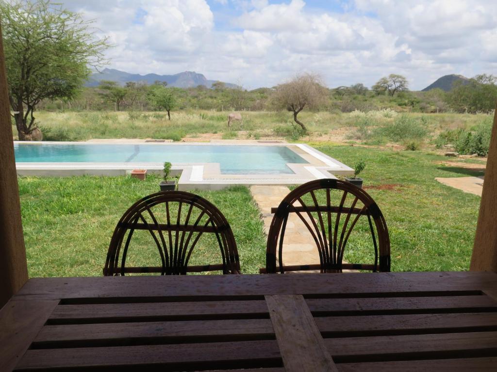 2 sillas sentadas frente a una piscina en Samburu Dik-Dik House & Susuk Self-catering Cottage, en Archers Post