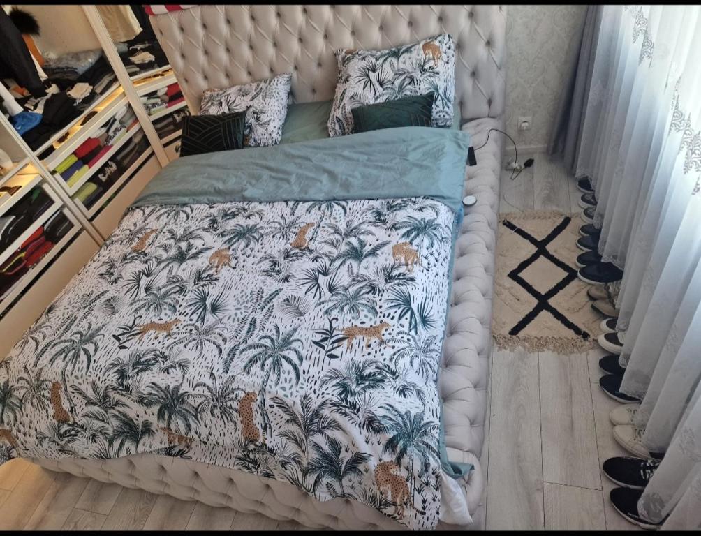 a bedroom with a bed with a tropical print at Diva lux in Brussels